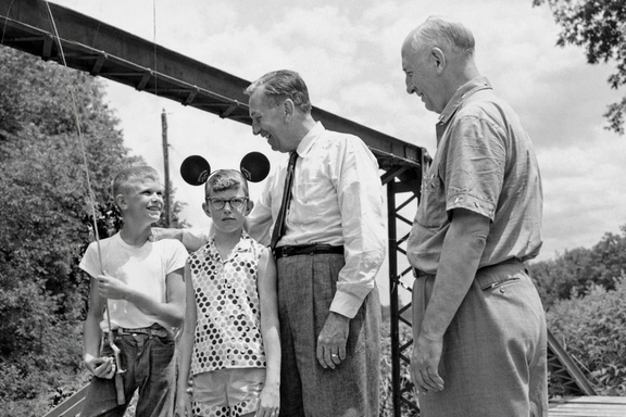 Walt and Roy Disney at Yellow Creek bridge, with kids and fishing pole